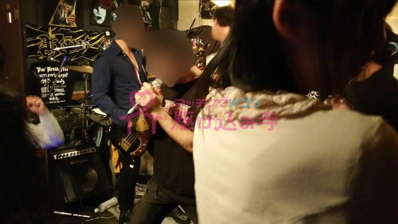 ライブハウスで熱唱している男性の写真