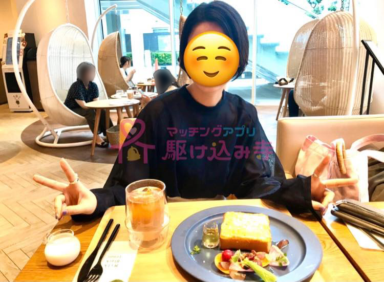 女性がカフェでピースしている写真