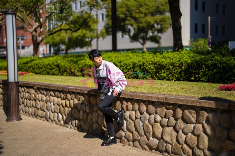 歩道で腰掛ける男性の写真