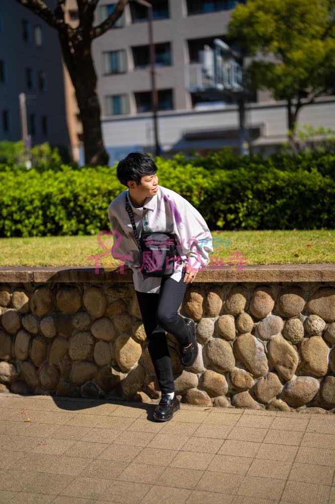 歩道で腰掛ける男性の写真